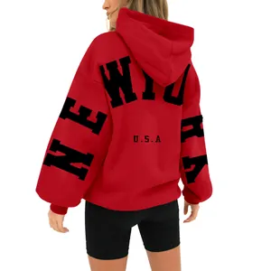 Back view of a red oversized fleece hoodie with bold black New York USA graphic print.