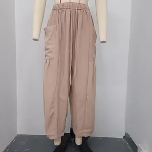 Close-up detail of women's pleated cotton linen pants with elastic waist and side pockets