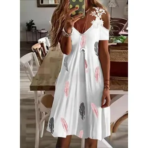 Detalle de un vestido blanco de verano con hombros descubiertos, encaje y plumas