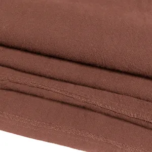 Close-up of the textured brown fabric and stitching of a medieval men's shirt