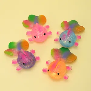 Detailed macro view of four colorful glittery goldfish-shaped maltose squishy toys on yellow