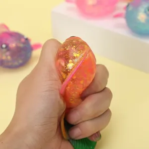 Detail shot of hand squeezing a glittery maltose goldfish toy for stress relief