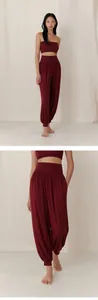 Detail of burgundy high-waisted yoga harem pants with soft breathable fabric.