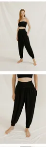 Detail of women's black loose yoga harem pants with high waist and cuffed ankles