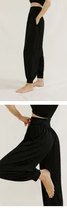 Detail view of black loose-fit yoga harem pants with high waistband and cuffed ankles