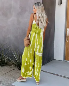 Vue arrière d'une femme portant une combinaison tie-dye verte à jambes larges et sac