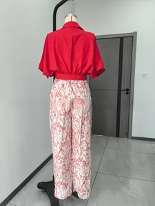 Vue arrière d'un ensemble d'été élégant avec haut rouge et pantalon large à fleurs.