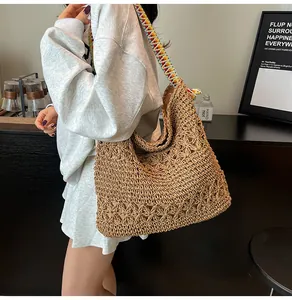 Detail view of large woven straw tote bag with colorful wide shoulder strap