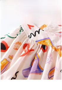 Macro detail of baby girls artistic print summer dress featuring delicate waist pleats