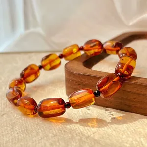 Detail close-up of a vintage natural amber beeswax beaded bracelet in warm orange