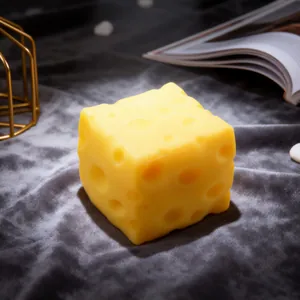Realistic yellow cheese shaped squishy decompression toy on elegant grey velvet background