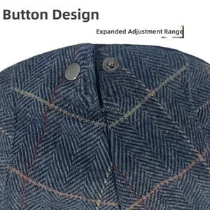 Close-up of adjustable metal snap buttons on a retro blue herringbone wool ivy beret cap.