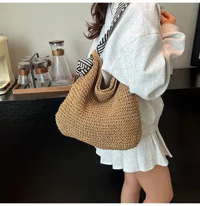 Large capacity straw woven tote bag with nautical striped strap shown on an Asian model