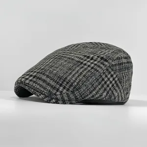 Close-up detail of grey and black houndstooth wool pattern on a vintage British flat cap