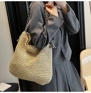 Large capacity straw woven tote bag featuring a navy striped strap shown on a model