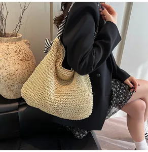 Detailed view of large straw woven tote bag with nautical striped shoulder strap