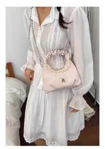 Cute pink ruffled handbag with lace trim and bear patch for stylish women's use.