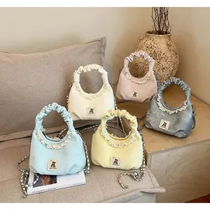 Macro view of pleated handbags with ruffled lace and cute bear patch in multiple colors.