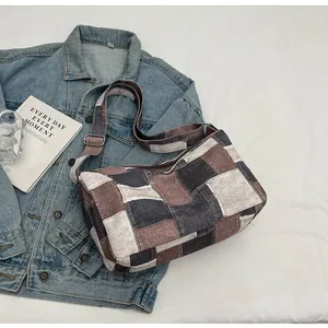 Detail einer Patchwork-Jeanstasche im Karodesign mit verstellbarem Trageriemen.