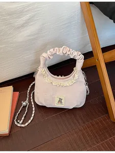 Detailed macro view of the cute pink pleated handbag featuring lace trim and bear patch.