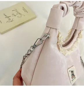 Detailed macro view of pink ruched handbag featuring cute bear patch and lace trim
