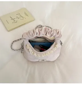 Detail of pink pleated handbag showing spacious interior with cosmetics and phone