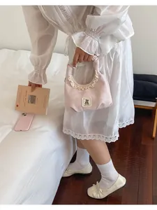 Cute pink ruffled handbag with embroidered bear patch shown in a cozy lifestyle setting