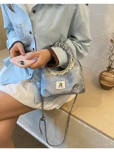 Detailed view of silver scrunchie handle handbag with lace trim and cute bear patch.