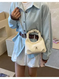 Elegant small white handbag featuring a ruffled handle and cute bear patch detail