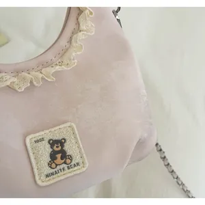 Detailed macro view of pink cute bear crossbody bag with elegant lace trim decoration
