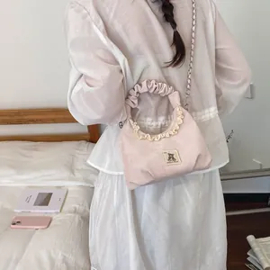Cute pink ruffled handbag featuring a teddy bear patch and elegant silver chain strap