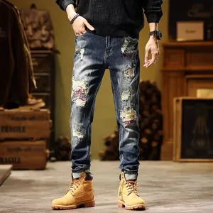 Close-up detail of men's retro distressed slim straight jeans with unique patches