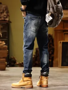 Back view of high-quality men's vintage slim-fit distressed denim jeans in blue wash