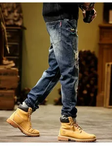Vintage distressed blue denim jeans for men with colorful patchwork and rip details