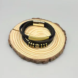Detail of men's multi-layer black leather braided bracelet with gold magnetic clasp