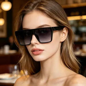 Close-up of stylish oversized square sunglasses with black frames and gradient lenses.