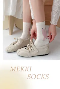 Cute cream-colored crew socks featuring a pink cartoon cat pattern and polka dots