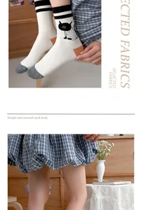 Close-up detail of cute cartoon cat pattern on white thin cotton mid-calf socks.