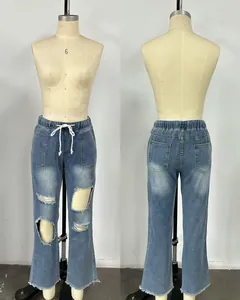 Detail of women's blue ripped denim jeans featuring a comfortable elastic drawstring waist