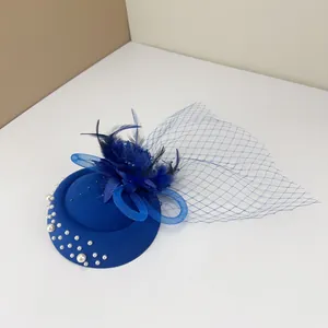 Detail view of a blue vintage fascinator hat with feathers, mesh veil and white pearls