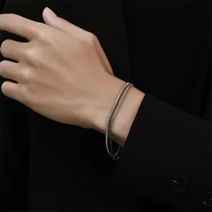 Close-up detail view of a titanium steel double-layer bracelet worn on a person's wrist.