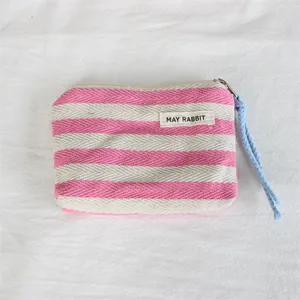 Detailed view of a pink and white striped canvas coin purse with MAY RABBIT label.
