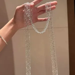 Detailed view of elegant sparkly silver mesh net long sweater necklace held by hand