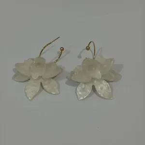 Detailansicht eleganter weißer Harz-Blumenohrringe mit vergoldeten Haken für Damen