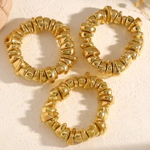 Detailansicht von drei goldenen unregelmäßigen Kunstperlenarmbändern auf Hintergrund