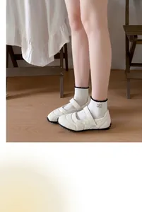 White academy style ruffled mid-calf socks with a charming small fabric tag detail