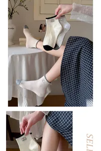 Detail view of Korean style women's cotton socks with ruffled edges and dog label.