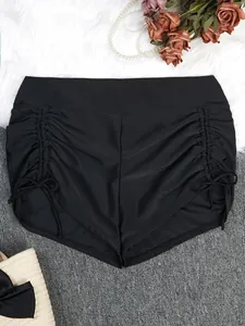 Detail view of black high waisted swim shorts with ruched drawstring sides