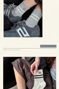 Detail of combed cotton crew socks with cute bear embroidery and striped cuff design.