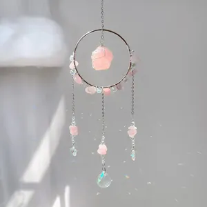 Détail d'un attrape-soleil en quartz rose avec prismes de cristal et arcs-en-ciel